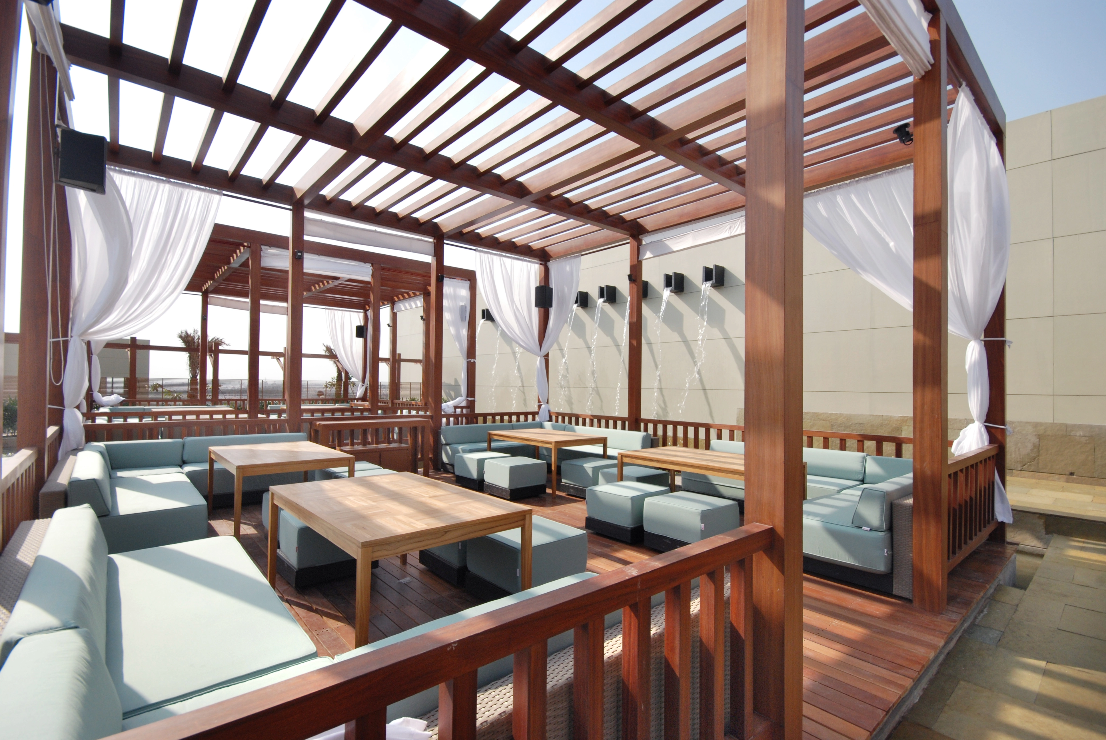 Design Swissotel Hotel outdoor lounge in Nashik with modern seating, wooden pergolas, & elegant decor